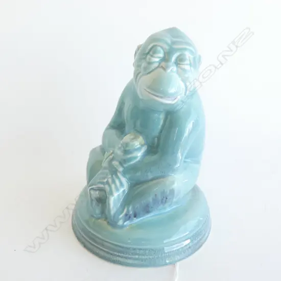 A Beswick monkey holding a piece of fruit